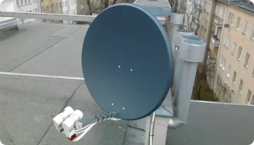 Antena satelitarna w kolorze grafitowym, z dwoma konerterami na Astrę i Hotbirda na dachu bloku w Warszawie